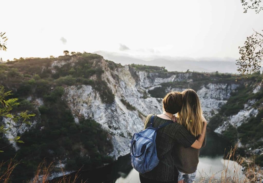 Twee vrouwen knuffelen boven op een berg.