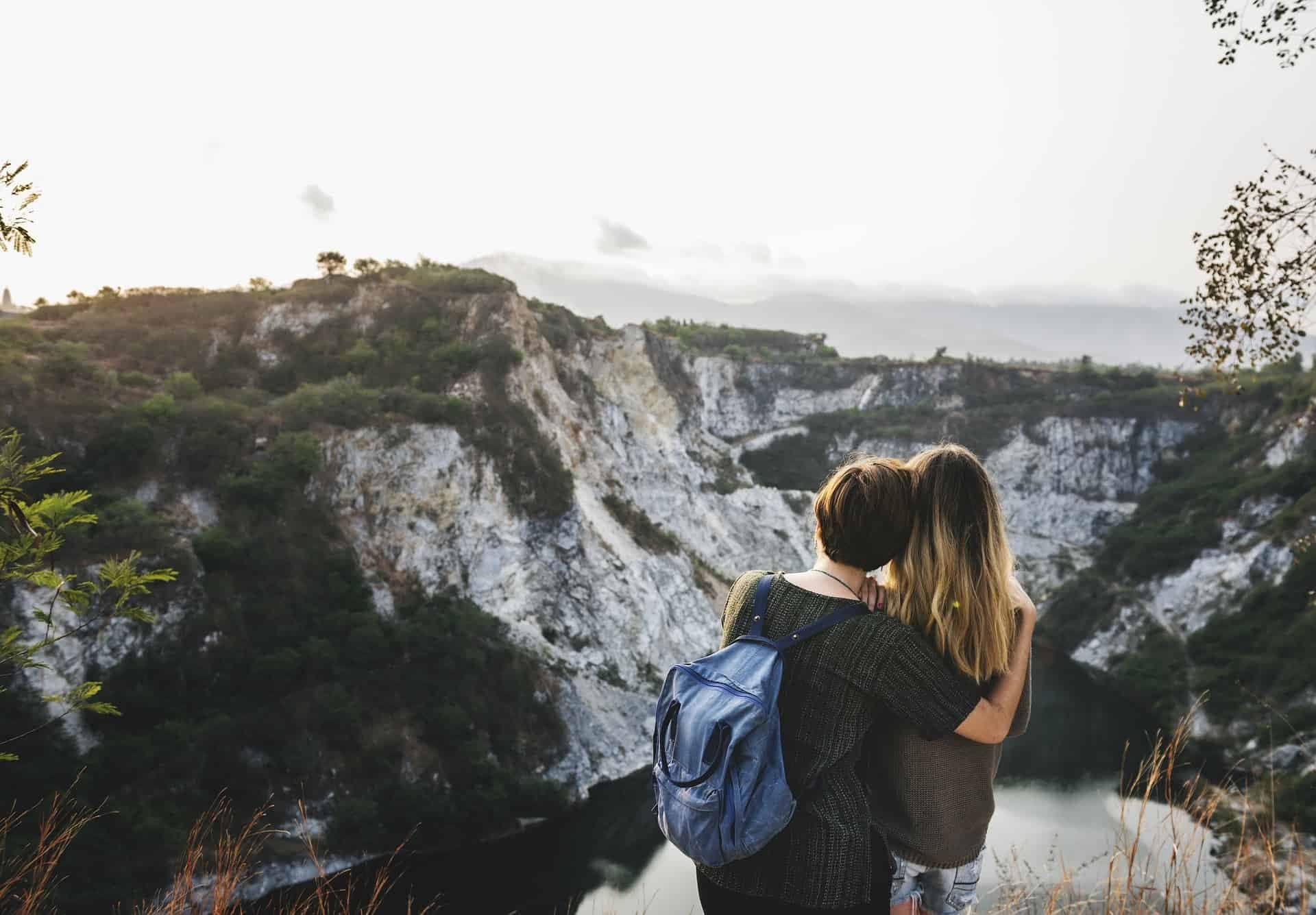 Twee vrouwen knuffelen boven op een berg.
