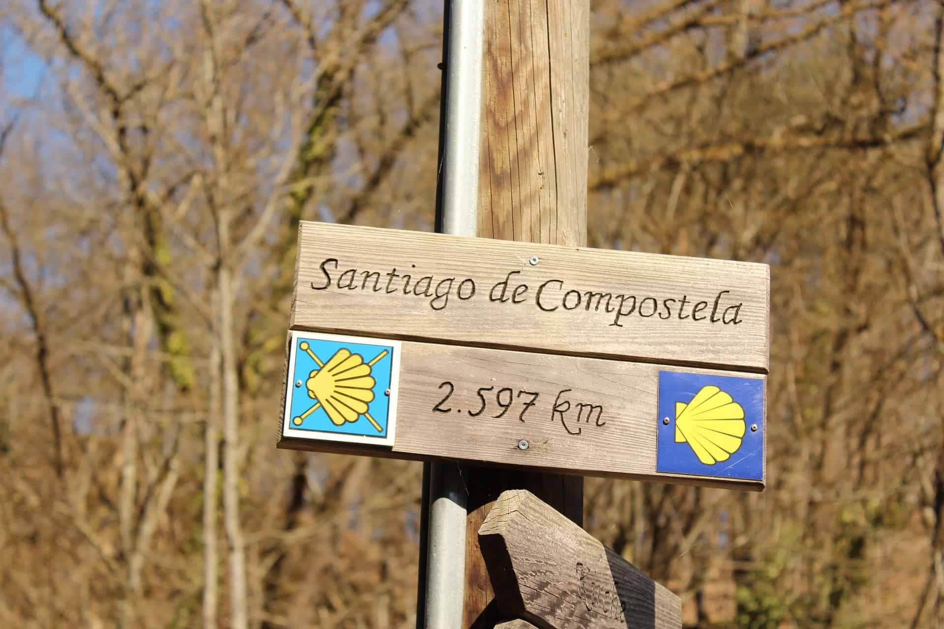 Houten bord Santiago de Compostela met aantal kilometers.